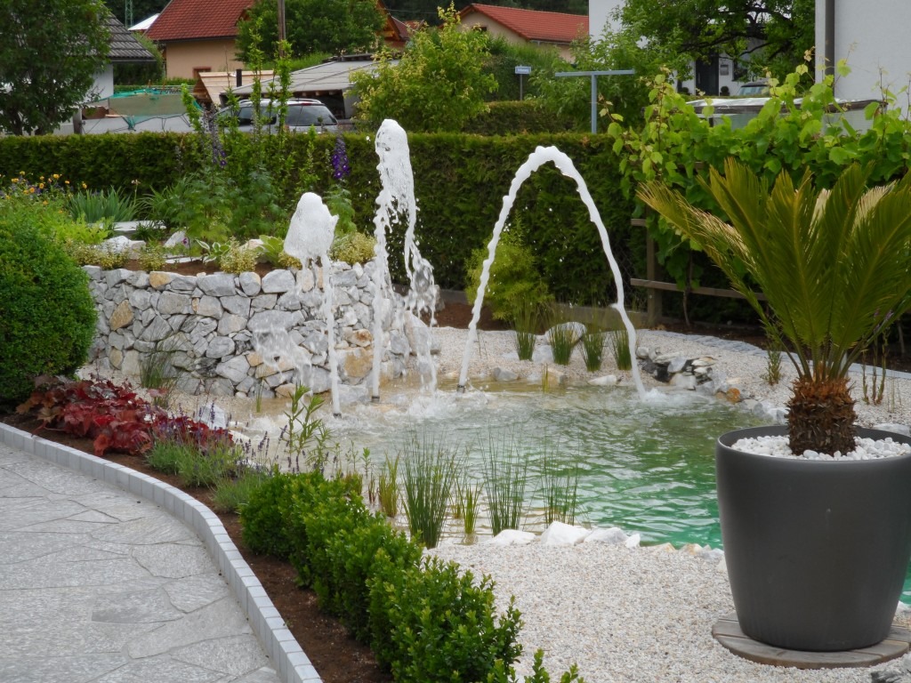 Mediterrane Gartengestaltung am Wasser Mittelmeerpflanzen an einem Gartenteich mit sonnigem Sitzplatz